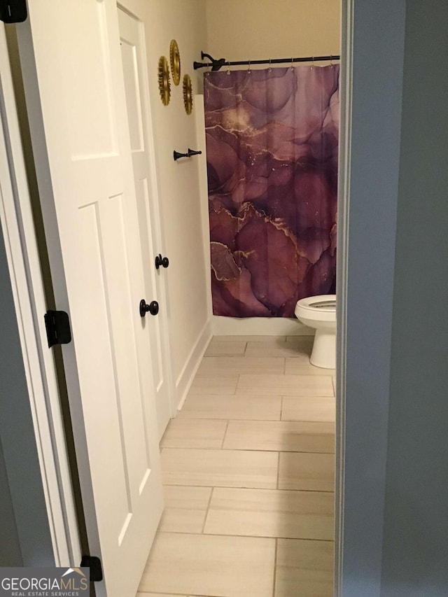 bathroom featuring curtained shower and toilet