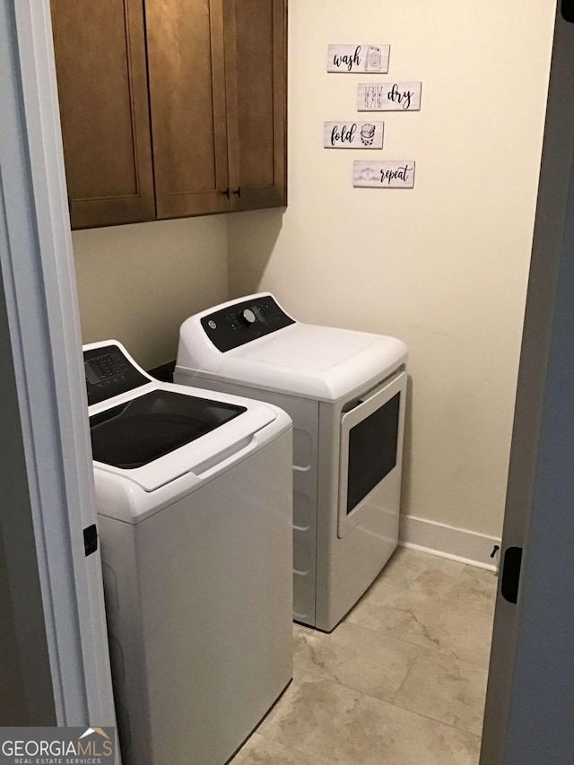 washroom with cabinets and washer and dryer