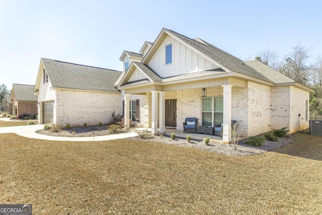 view of front of home featuring a porch, brick siding, concrete driveway, roof with shingles, and board and batten siding