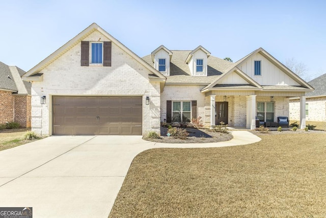 view of front of house featuring driveway, a front yard, a porch, and brick siding