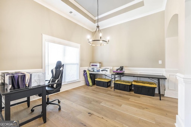 office with ornamental molding, a tray ceiling, a wainscoted wall, and wood finished floors