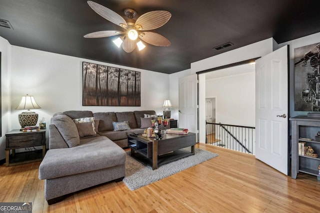 living room featuring wood-type flooring and ceiling fan