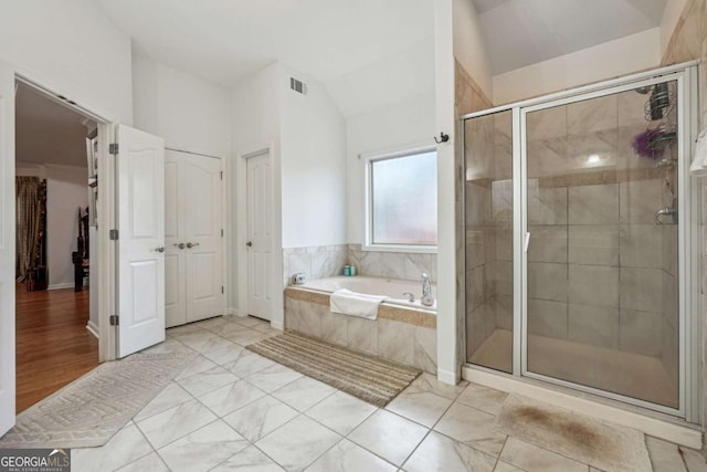 bathroom featuring vaulted ceiling and shower with separate bathtub