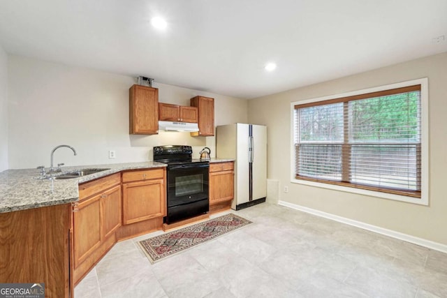 kitchen with white refrigerator, light stone countertops, sink, and black range with electric cooktop