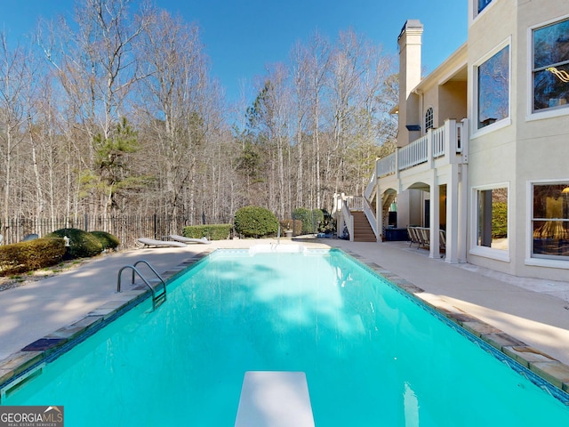 view of swimming pool with stairs, a patio, a diving board, and a fenced in pool