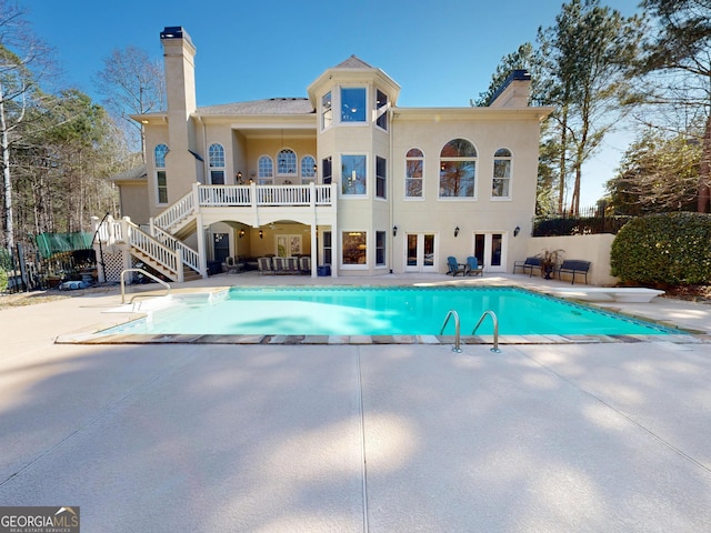 back of house featuring french doors, a patio area, and a chimney