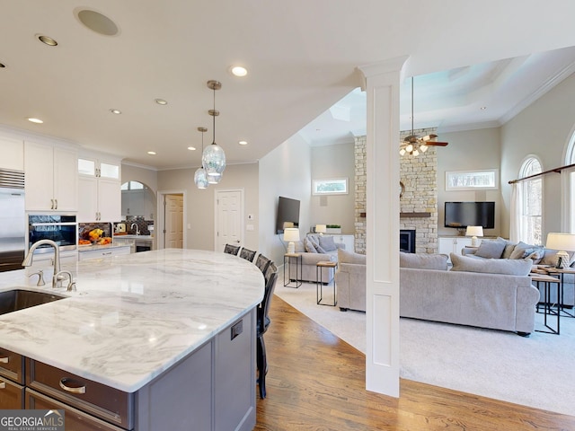 kitchen featuring crown molding, open floor plan, oven, and a fireplace