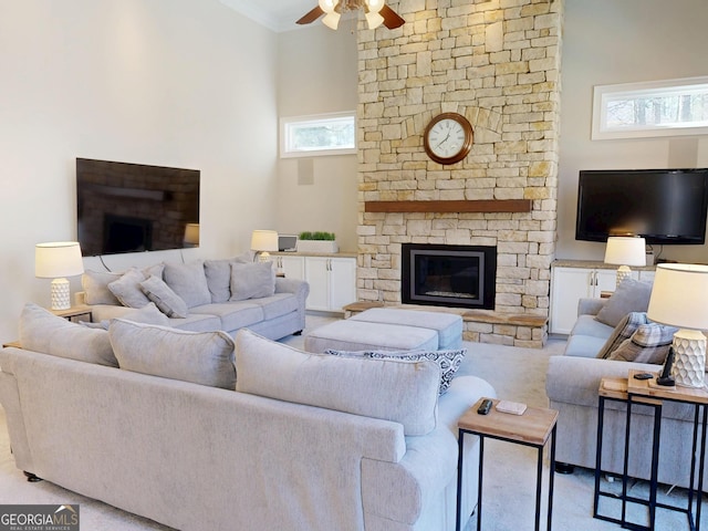 carpeted living area with ornamental molding, a fireplace, and ceiling fan