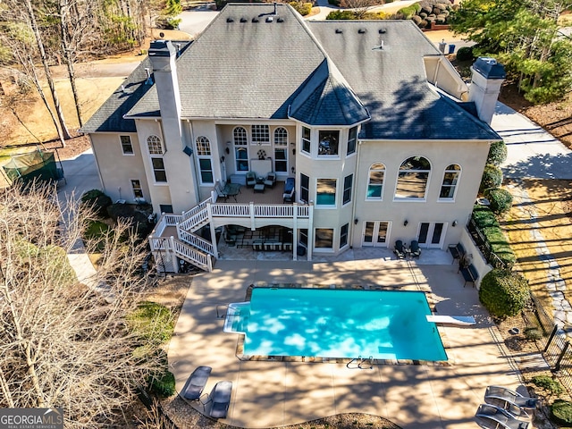 back of house featuring a patio, a chimney, stairs, french doors, and stucco siding