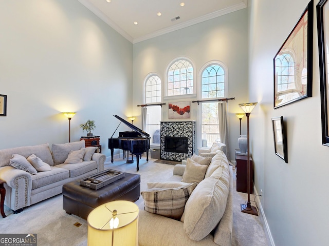 living room with light carpet, a tiled fireplace, and a high ceiling