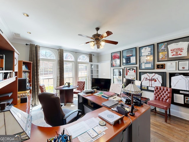 office area featuring baseboards, visible vents, a ceiling fan, wood finished floors, and crown molding