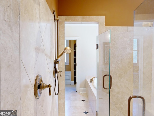 bathroom featuring tiled tub, a shower stall, and tile patterned floors