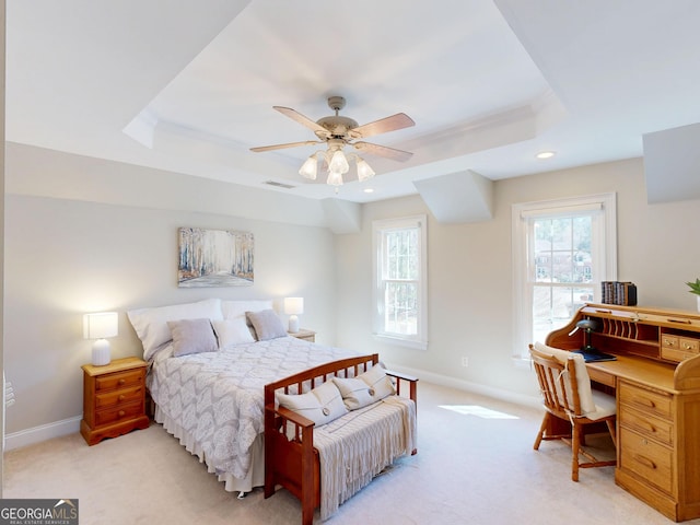 bedroom featuring visible vents, a tray ceiling, baseboards, and light colored carpet