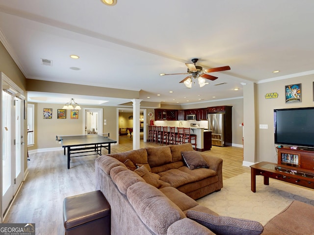 living room featuring light wood-type flooring, decorative columns, ornamental molding, and recessed lighting