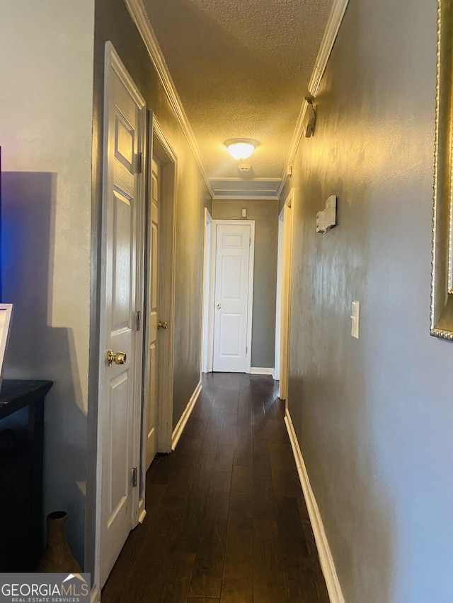 hallway featuring ornamental molding, dark hardwood / wood-style flooring, and a textured ceiling