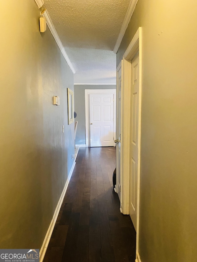 hallway with dark hardwood / wood-style flooring, crown molding, and a textured ceiling