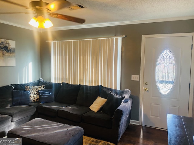 living room with ceiling fan, ornamental molding, dark hardwood / wood-style flooring, and a textured ceiling