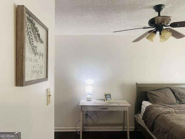 bedroom with ceiling fan and a textured ceiling