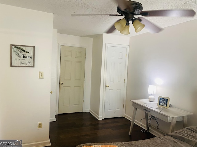 bedroom featuring ceiling fan, dark wood-type flooring, and a textured ceiling