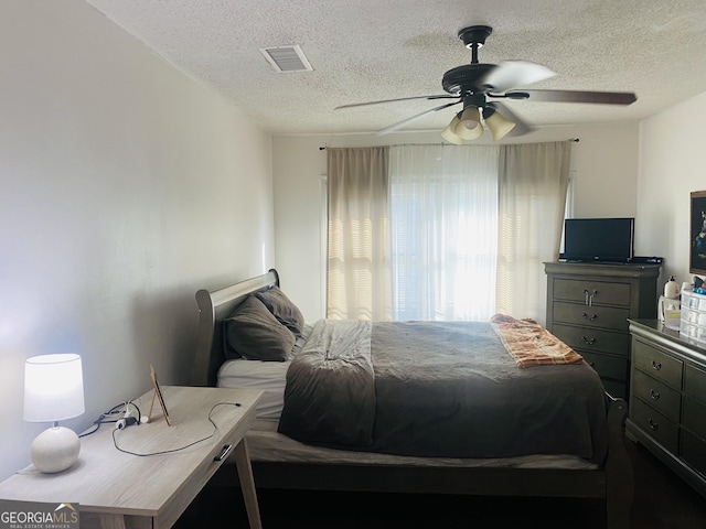 bedroom featuring ceiling fan and a textured ceiling