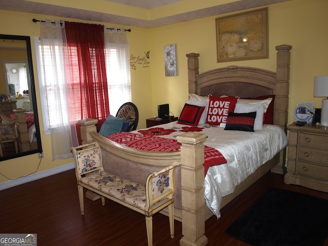 bedroom featuring a fireplace and dark wood-type flooring