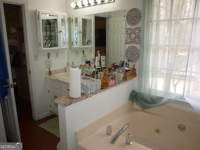 bathroom with vanity, a tub to relax in, and wood-type flooring