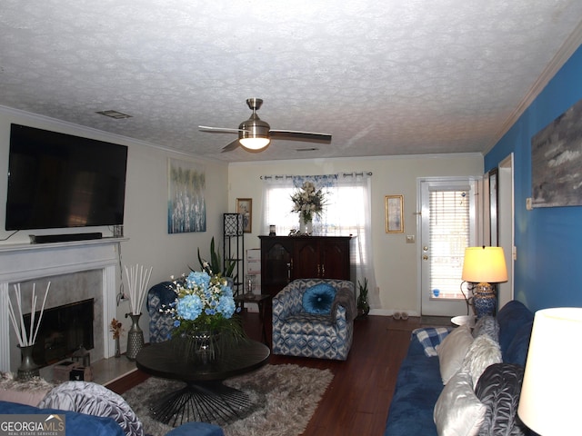 living room featuring ornamental molding, dark hardwood / wood-style floors, a high end fireplace, and a textured ceiling