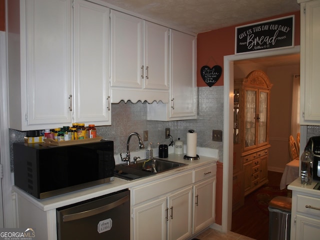 3738 Windy Hill Dr SE, Conyers, GA 30013 - kitchen with black microwave, a sink, dishwasher, white cabinets, and decorative backsplash