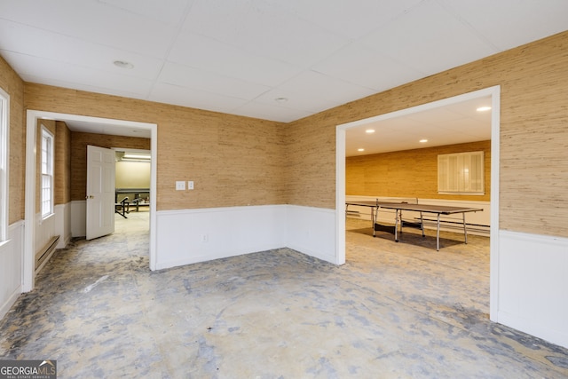 spare room with concrete floors and a drop ceiling