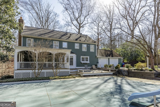 back of house featuring a garage and a deck