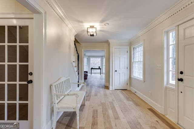 foyer featuring ornamental molding and light hardwood / wood-style flooring