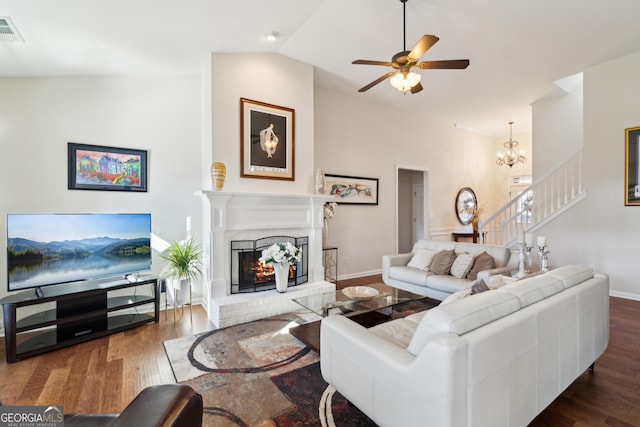 living room featuring a fireplace, dark wood-type flooring, ceiling fan with notable chandelier, and lofted ceiling