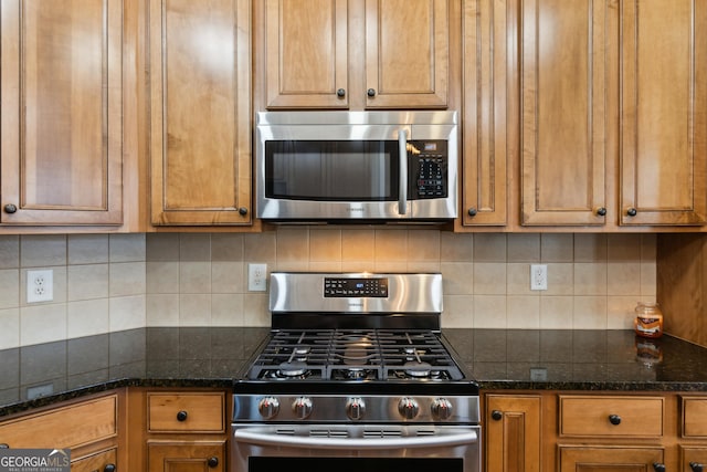 kitchen featuring dark stone countertops, appliances with stainless steel finishes, and decorative backsplash