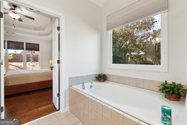 bathroom with tile patterned flooring, crown molding, a wealth of natural light, and a raised ceiling