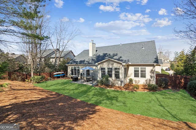 rear view of house with a patio and a lawn