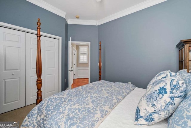 carpeted bedroom featuring ornamental molding and a closet