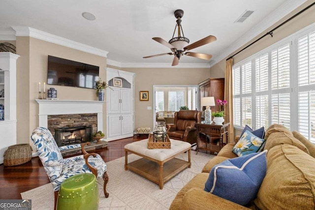 living room featuring a fireplace, crown molding, light hardwood / wood-style flooring, and ceiling fan