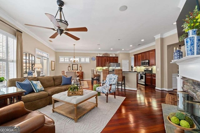 living room with crown molding, plenty of natural light, dark wood-type flooring, and a fireplace