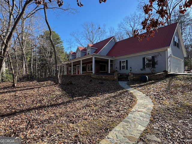 rear view of house featuring metal roof and an attached garage