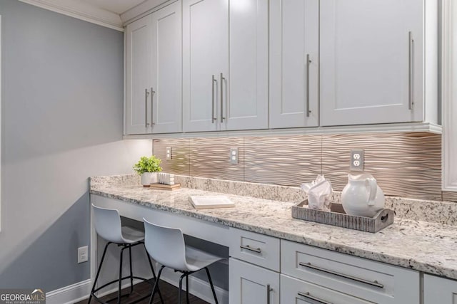 3847 Admiral Dr, Chamblee, GA 30341 - kitchen with backsplash, white cabinetry, light stone counters, crown molding, and an office area