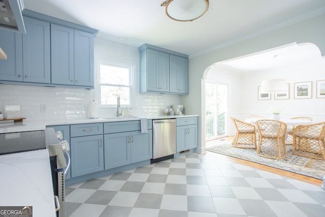 kitchen with appliances with stainless steel finishes, tasteful backsplash, sink, crown molding, and blue cabinetry