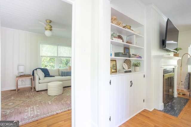 corridor with light hardwood / wood-style flooring and ornamental molding