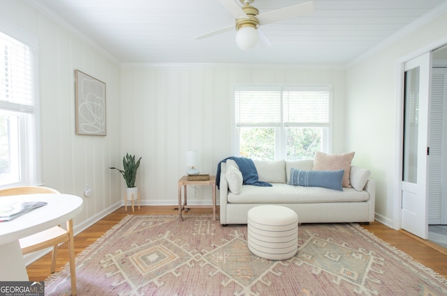 living area with hardwood / wood-style flooring, crown molding, and ceiling fan