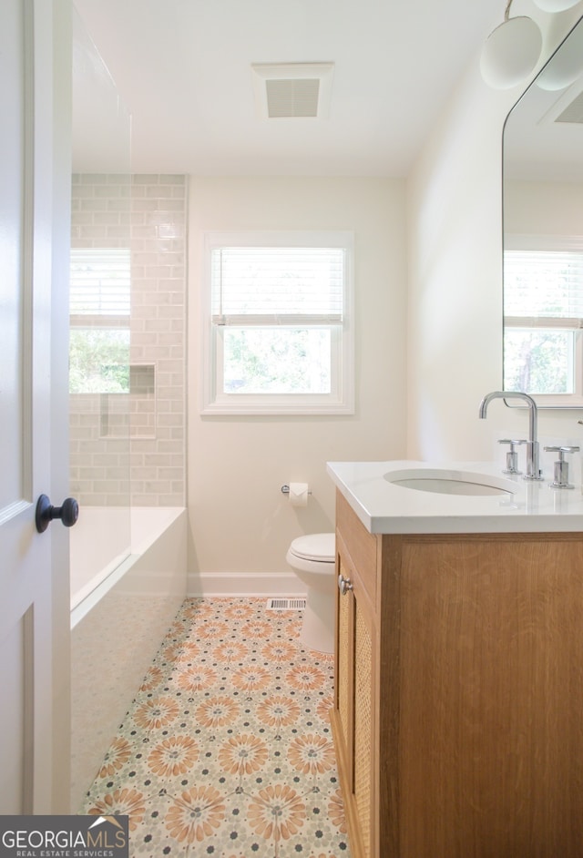 bathroom with vanity, toilet, and a healthy amount of sunlight