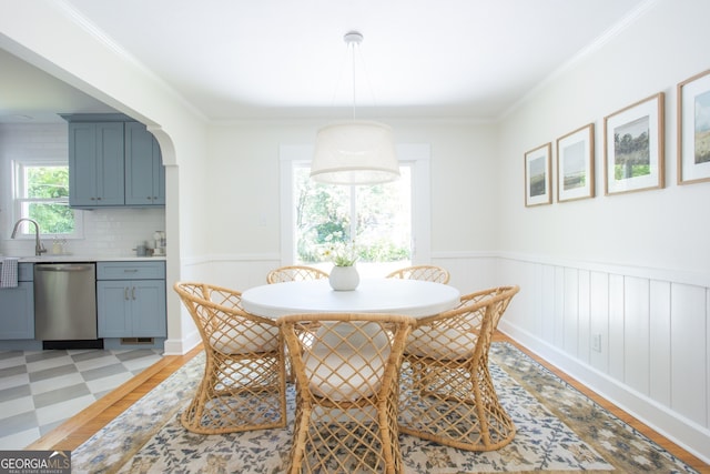 dining room with light hardwood / wood-style flooring and ornamental molding