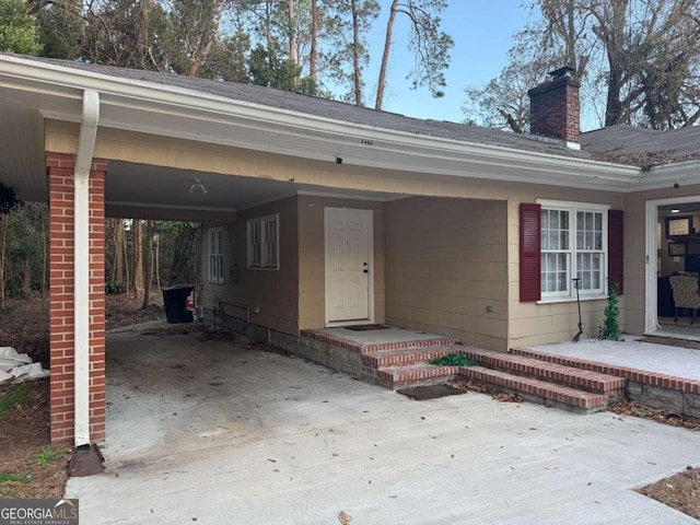 view of exterior entry with a carport