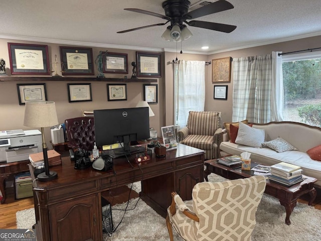 home office featuring crown molding, light hardwood / wood-style flooring, a textured ceiling, and ceiling fan