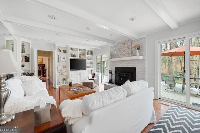 living room featuring a fireplace, beam ceiling, and light hardwood / wood-style flooring