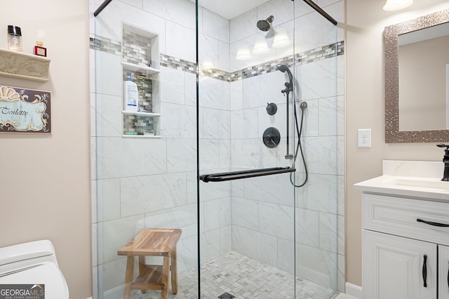 bathroom with a shower with door, vanity, and toilet