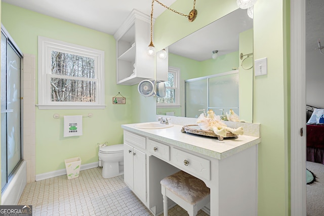 full bathroom featuring vanity, toilet, and combined bath / shower with glass door